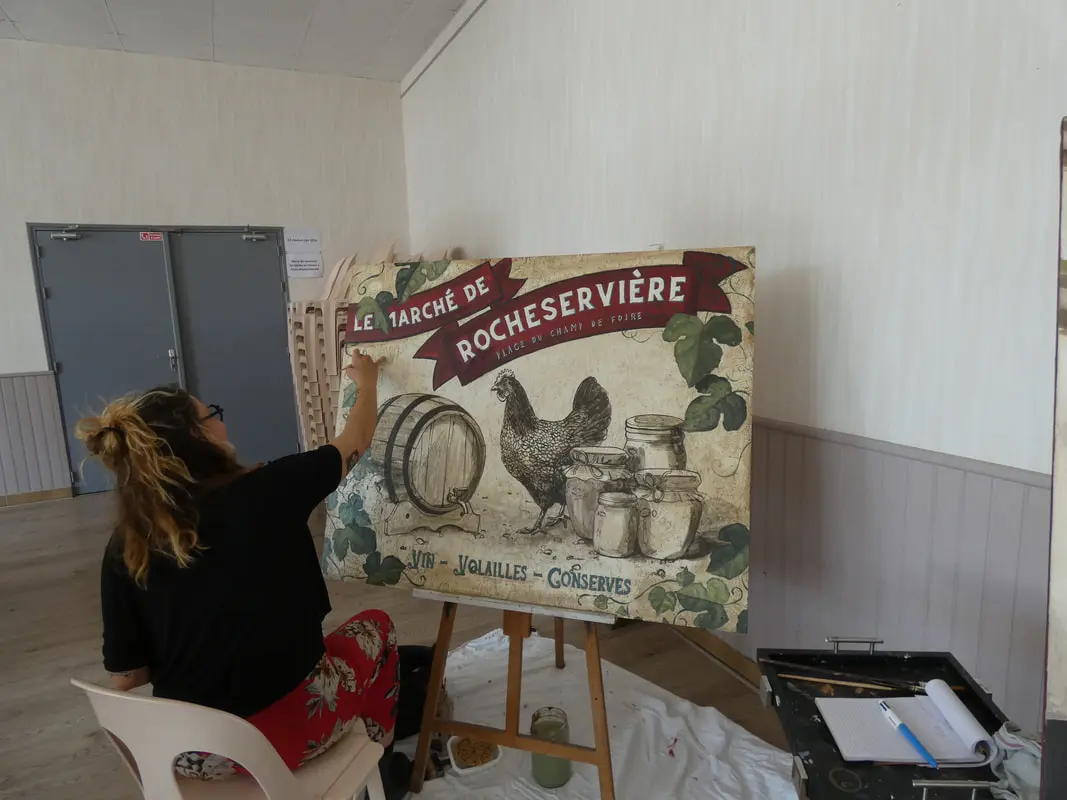 Artiste peinture peignant pendant le festival un tableau qui représente le marché de Rocheservière