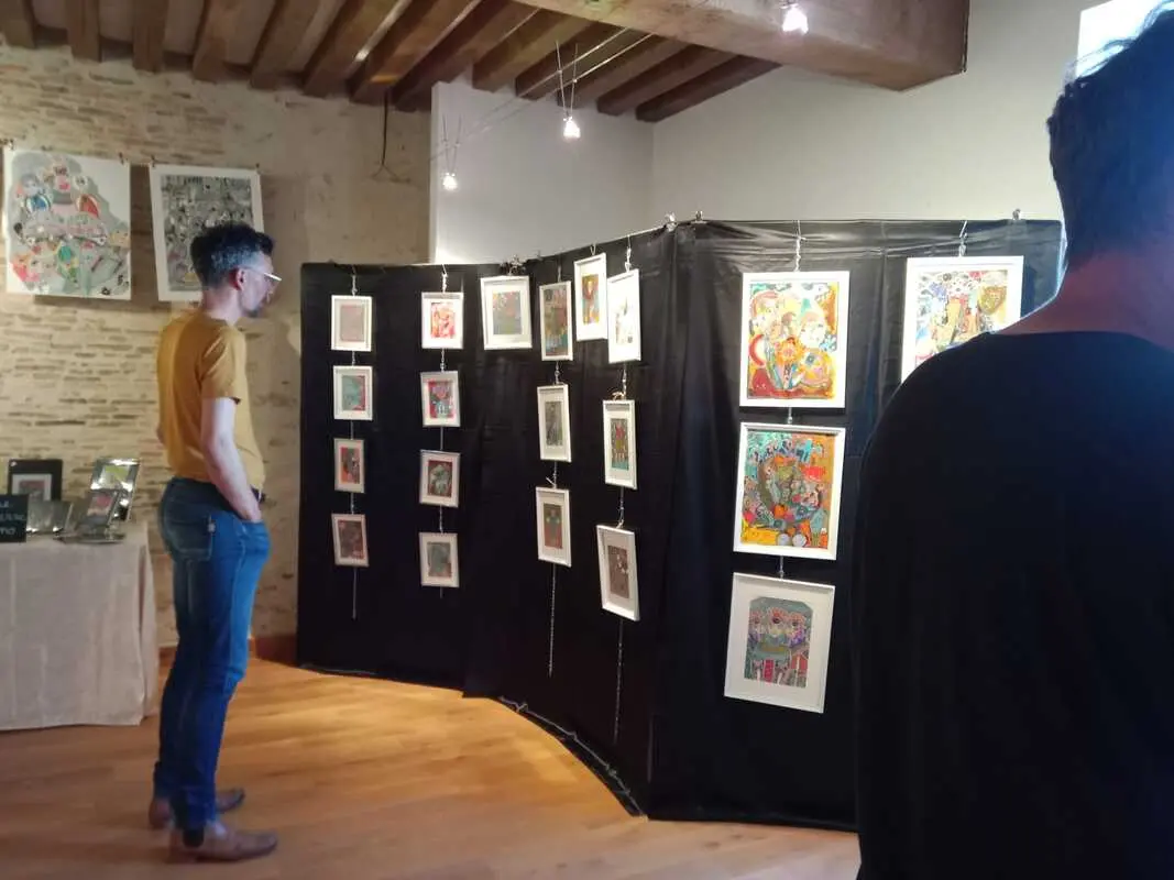Une personne qui observe des tableaux exposés pendant le festival à l'intérieur d'une galerie